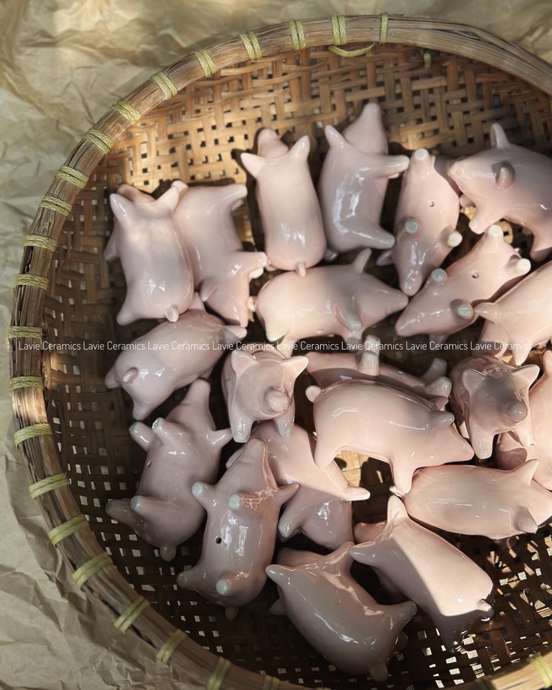 Heo gốm màu hồng trong rổ tre